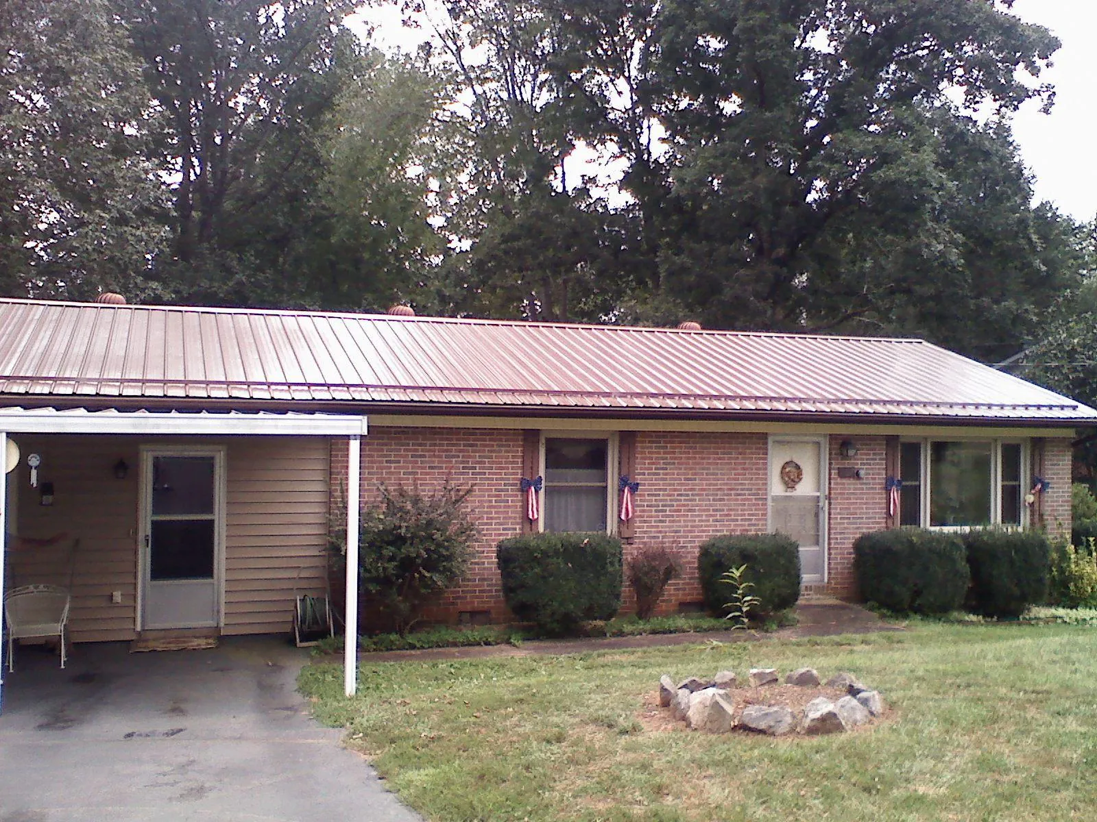 Bronze metal roof and carport on a brick ranch home — Roof Repair work by our crew in Round Lake